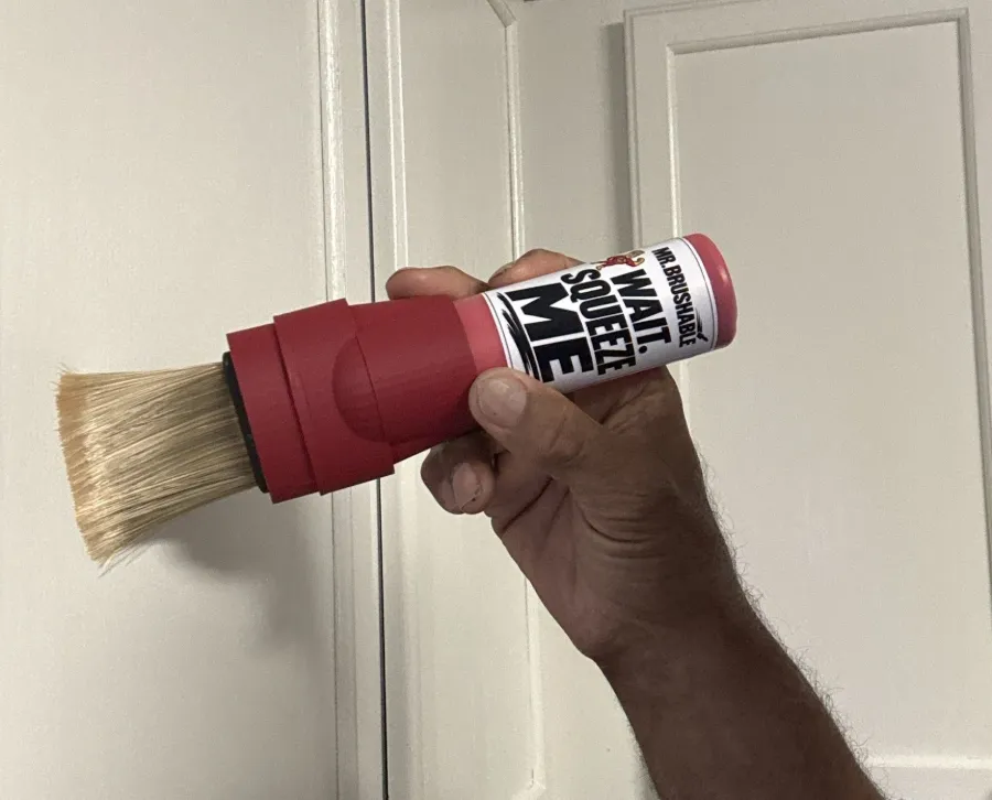 A red Mr. Brushable brush bottle touching up a white door